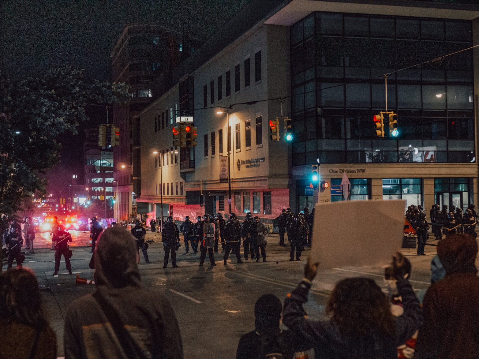 Demonstrators with Protest Signs Facing Police Officers
